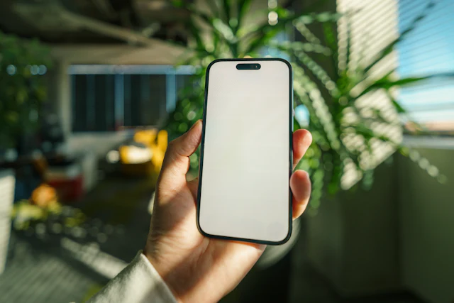 A smartphone held in a modern green workspace