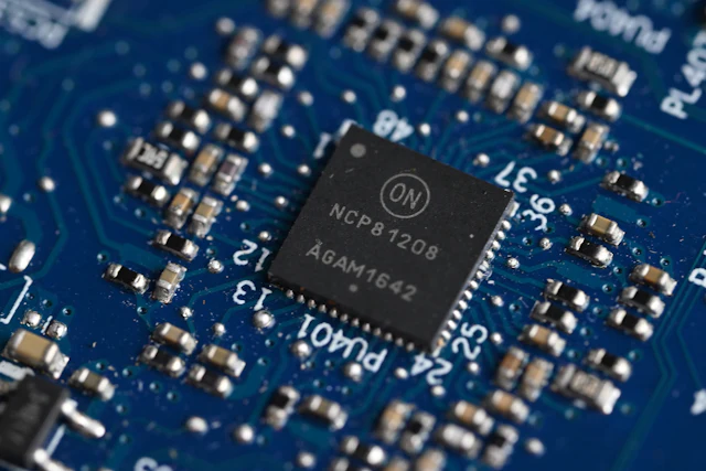 A blue microchip surrounded by precise electronic circuitry